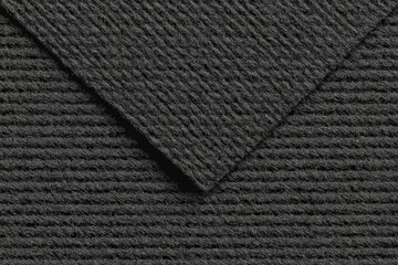 Dark gray textured fabric, closely woven, showing diagonal folds