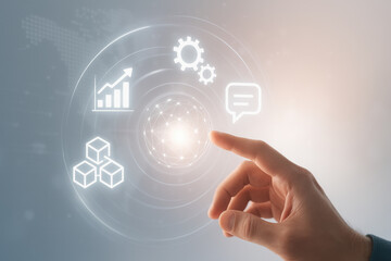Hand pointing at digital interface with icons of graph, gears, chat, and cubes in soft light