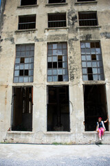 Traveler thai women people travel visit abandoned ruin ancient industrial building of Old Kanchanaburi Thai Paper Mill Industry Factory architecture of World War II landmarks in Kanchanaburi, Thailand