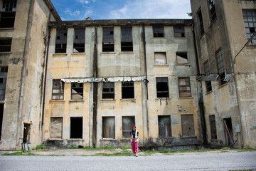 Travelers thai women people travel visit and portrait posing for take photo with abandoned ruins building of Kanchanaburi Thai Paper Mill Factory architecture of World War II in Kanchanaburi, Thailand