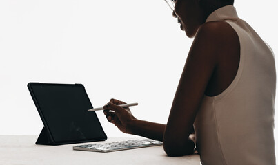 Naklejka premium Professional woman using a stylus with a tablet and keyboard
