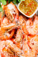 Grilled shrimps with spicy sauce in a white tray.