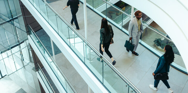 Businesspeople walking through modern office building interior