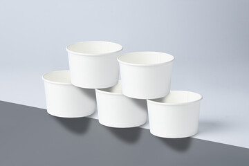 Three white 160 cc paper cups are placed side by side on the bottom and two are placed between two cups on top, resting on the edge of a white surface.