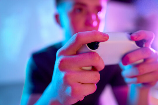Hands of gamer holding controller at home