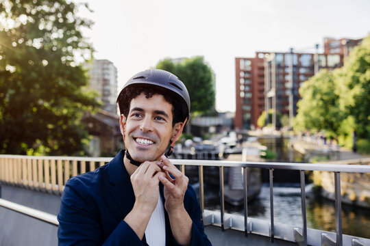 Person fastening bicycle helmet outdoors in urban business area