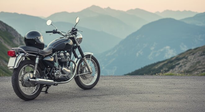 Vintage motorcycle parked on a mountain road with scenic mountain view
