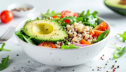 lose-up of fresh salad bowl with vegetables, avocado, and grains on white kitchen table