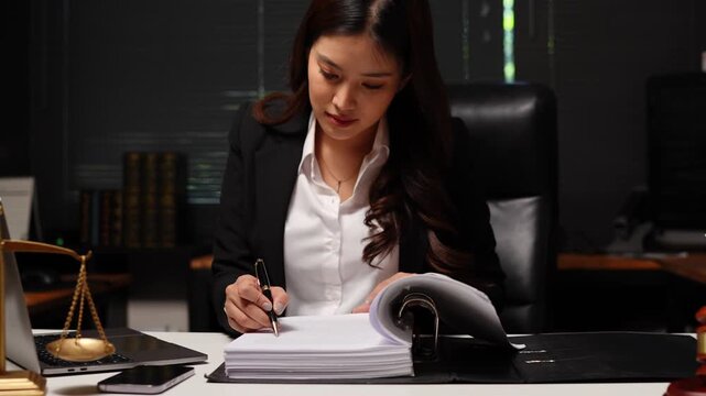 Female lawyer sat reviewing legal documents.