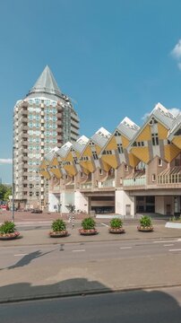 Hyperlapse of Cube House (Kubuswoningen) in Rotterdam. Unique yellow cube-shaped houses showcasing innovative architecture amid cityscape aerial timelapse. Cloudy sky and urban vibrancy. Netherlands