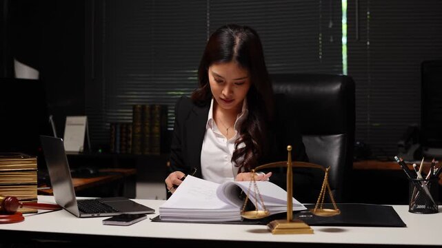 Female Lawyer Reviewing Legal Documents in Law Firm Office