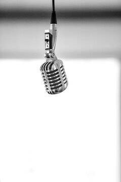 An old school microphone hanging from the ceiling - monochrome - vertical