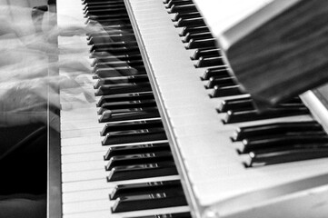 Hands playing piano in monochrome - horizontal