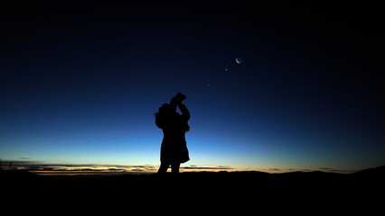 Amateur astronomer looking at the evening skies, observing planets, stars, Moon and other celestial...