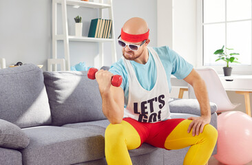 Serious man in a funny retro sportswear engaged in a fitness routine at home gym. Performs exercises with dumbbells, focusing intently on sport training. Humor and sport adds character to workout.
