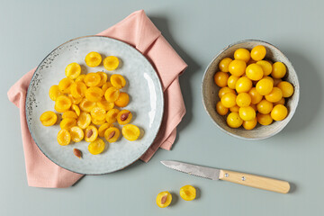 Mirabelle plums cut and whole with knife in studio setting