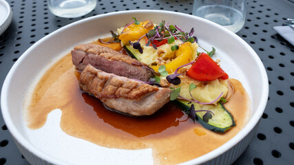 Grilled chicken breast served with vibrant vegetables and a rich sauce, showcasing a colorful and balanced meal that embodies freshness and vitality