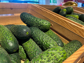 Fresh green cucumbers piled in wooden crates, showcasing vibrant textures and natural colors, representing healthy eating and farm-to-table freshness
