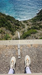 vista su strapiombo sul mare, i piedi sul bordo del precipizio