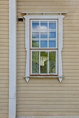 White window frame, green curtains, yellow wall on a old wooden building, Taavetti, Finland.