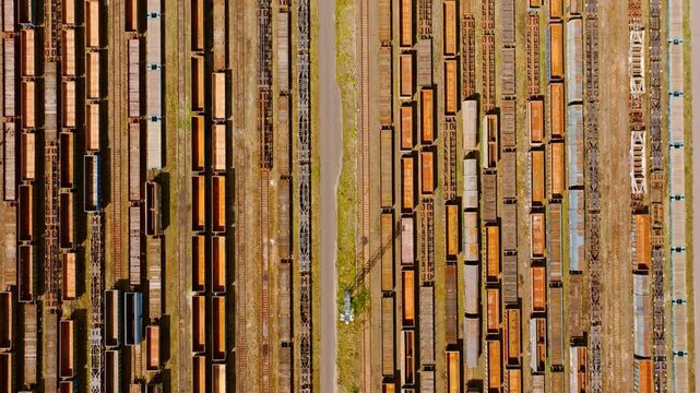 Rusty freight trains abandoned on parallel tracks creating industrial pattern