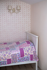 Colorful bed cover draped over a white wooden bed in a cozy bedroom, featuring floral patterns and...