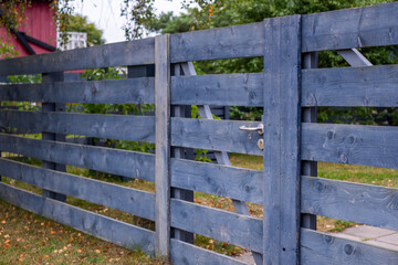 Sturdy rustic wooden fence with a charming blue finish, showcasing natural textures and durable...