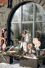 A woman walks along a city street on Christmas Eve in search of gifts and a good mood