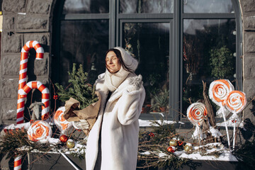 A woman walks along a city street on Christmas Eve in search of gifts and a good mood