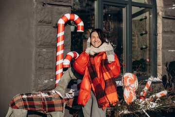 A woman walks along a city street on Christmas Eve in search of gifts and a good mood