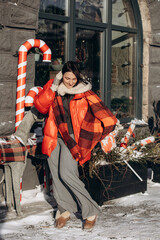 A woman walks along a city street on Christmas Eve in search of gifts and a good mood