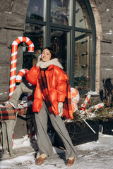 A woman walks along a city street on Christmas Eve in search of gifts and a good mood