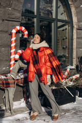 A woman walks along a city street on Christmas Eve in search of gifts and a good mood