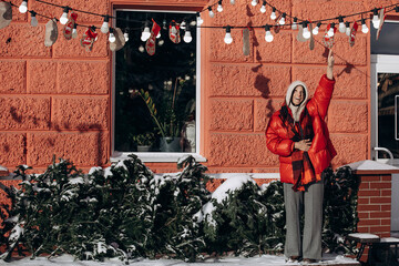 A woman walks along a city street on Christmas Eve in search of gifts and a good mood