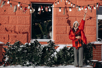 A woman walks along a city street on Christmas Eve in search of gifts and a good mood