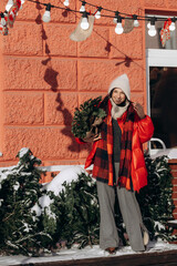 A woman walks along a city street on Christmas Eve in search of gifts and a good mood