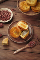 Traditional Chinese Mooncakes with Egg Yolk Filling and Red Beans on Rustic Wooden Background