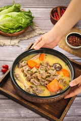 Nourishing braised duck casserole soup with vegetables and fresh ingredients on wooden table