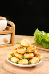 Pan-Fried Asian Dumplings with Sesame Seeds and Green Onions on Wooden Table