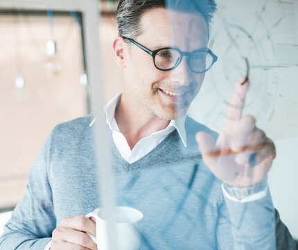 Smiling business professional planning at digital screen in office