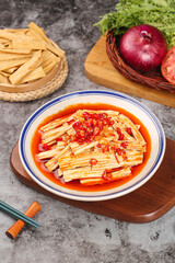 Spicy tofu with chili sauce Asian cuisine cold appetizer with bean curd sticks and fresh vegetables on wooden board