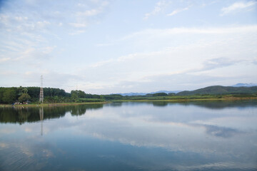 Fototapeta premium Clear calm lake with perfect reflections and mountain landscape on windy day
