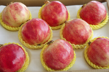 Fresh Red Pomegranates in Protective Packaging Box with Shallow Focus Food Photography