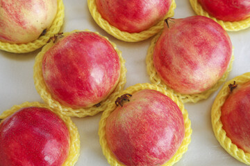 Fresh Red Pomegranates in Yellow Protective Foam Nets Box Packaging Display
