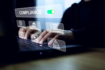 Compliance concept with a man in a black shirt working on laptop computer to implement the standard...