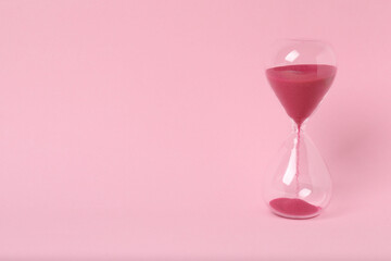 hourglass on a pink background
