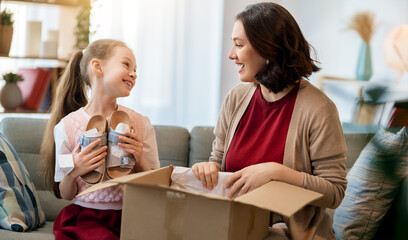 Mother and daughter are unpacking cardboard
