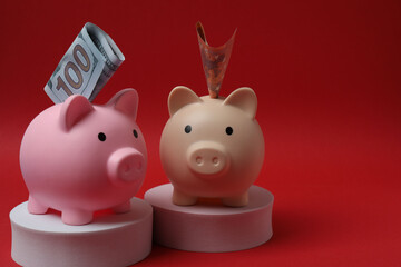 piggy bank, money dollars euros on a red background
