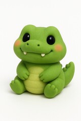 Obraz premium Cute green crocodile figurine sitting upright on a white surface, showcasing its adorable features and playful charm in a studio setting.