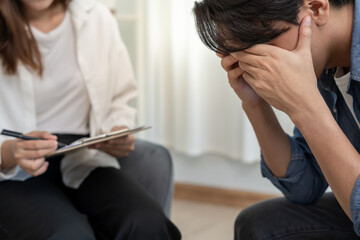man cover face felling sad from health problems. psychiatrist is recording the patient's condition for treatment. encouragement, love and family problem, bipolar , depression patient, protect suicide